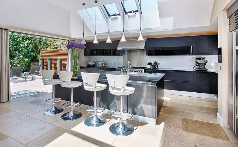 Light floods into the kitchen from a series of windows in the roof. The brightness has allowed the designers to choose black and charcoal-toned finishes without any risk of the place looking gloomy.