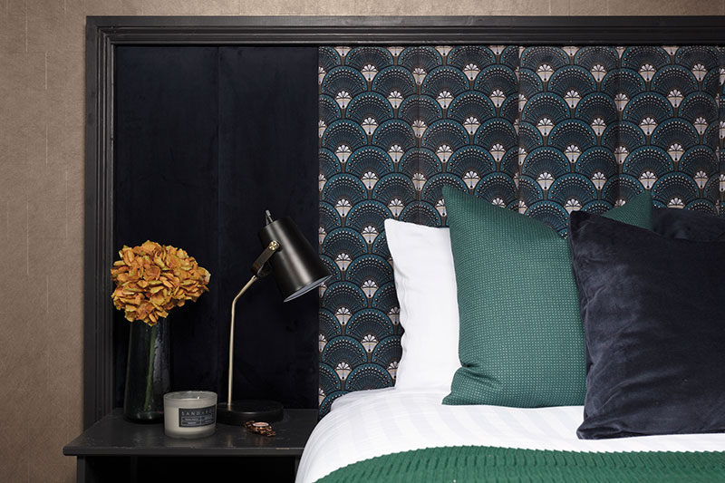 The guest bedroom follows the boudoir theme, mixing velvets with bold pattern