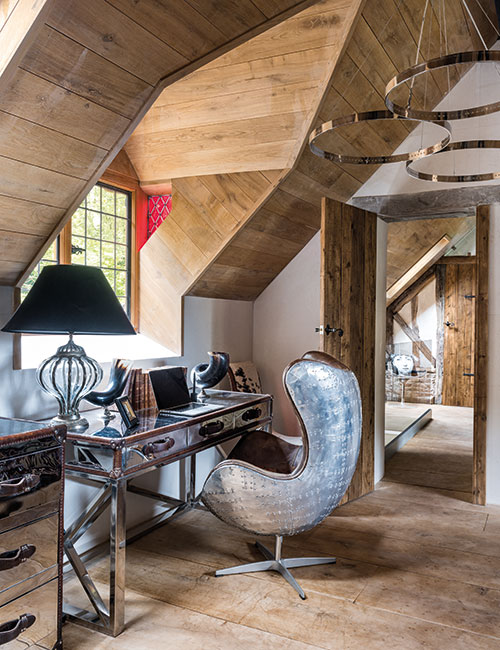 A work area is incorporated into the spacious main bedroom. The chrome desk and Aviation armchair are both from Andrew Martin. The internal doors throughout the house were made using reclaimed Scandinavian pine scaffold boards