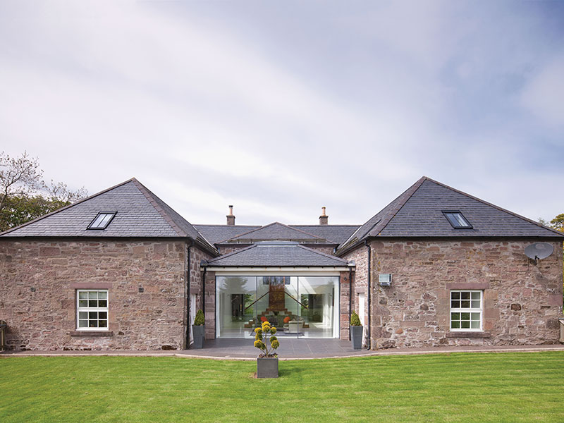 The back of the house with the rebuilt extension in the centre topped by its new slate roof. The Sky-Frame glazing and sliding door were supplied and installed by Gray & Dick