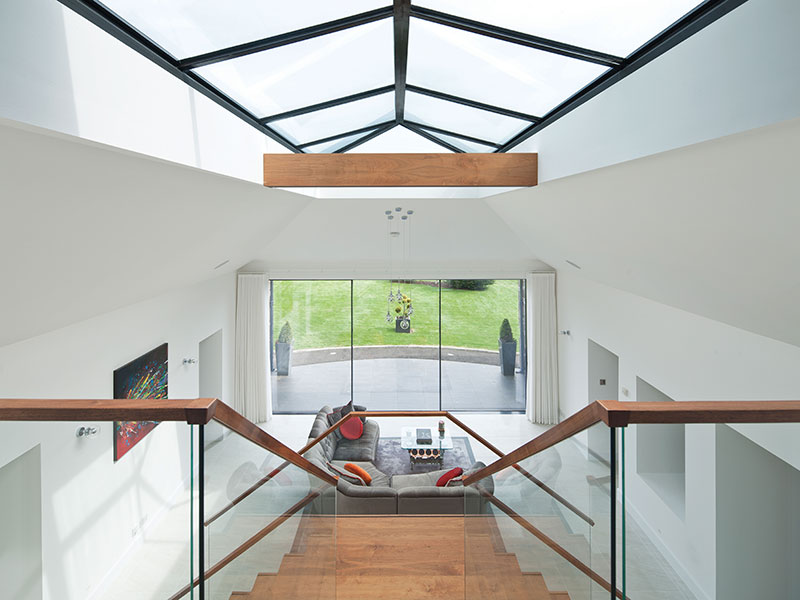 A timber-clad steel tie was necessary to hold the frame of the extension together. The sofa at the foot of the stairs is by John Sankey, while the coffee table, built from an old engine, is by Vee8Design. Booths of Inverurie installed the Lutron lighting system and the Occhio lights