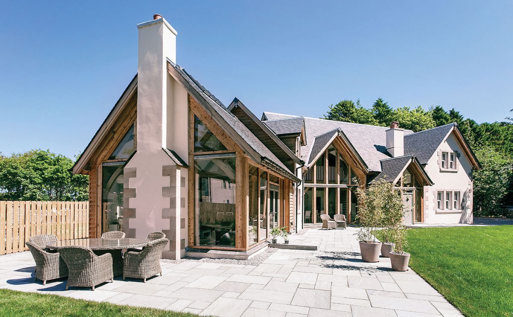 The house consists of two wings and a turret, with an exterior finish of larch cladding, stone and white K-Rend render