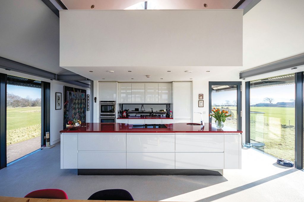 open-plan-white-kitchen-with-red-worktop