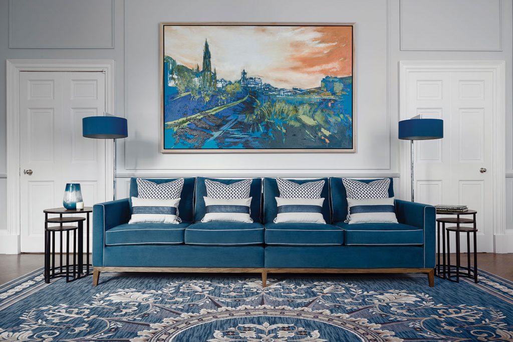 blue-sofa-with-painting-above-it