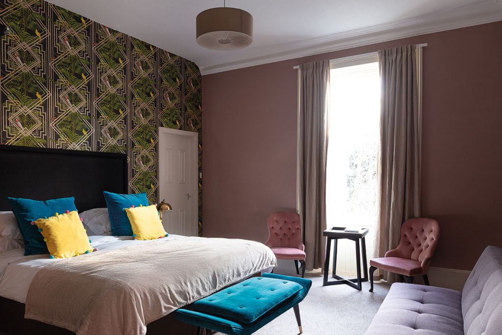 Saorsa-hotel-pink-room-with-blue-cushions-on-bed