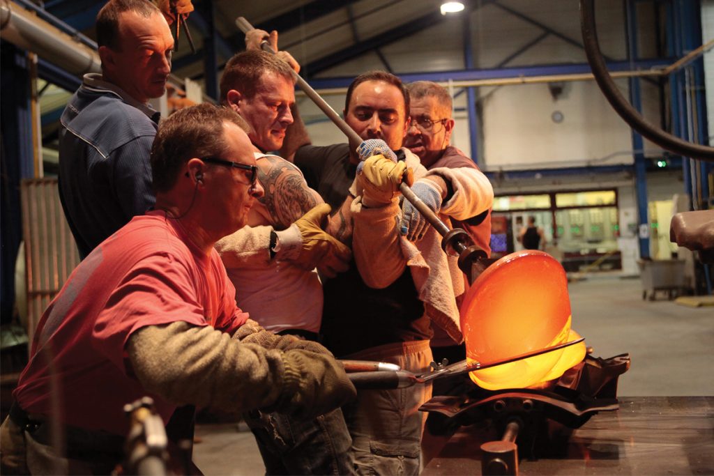 It’s not unusual for multiple craftsmen to work in tandem in the ‘hot glass’ workshop. 