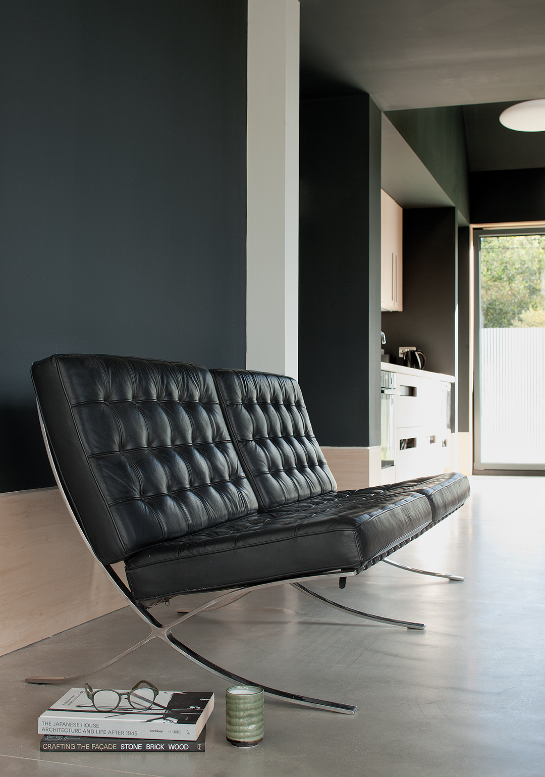 Barcelona-style chairs, view to kitchen island, light, plywood doors, dark, painted walls